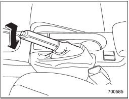 To release the parking brake, pull the lever up slightly, press the release button, then lower the lever while keeping the button pressed.